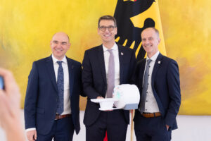 A photo of the three 2023 Future Prize winners Prof. Dr. Michael Uder University Hospital Erlangen, Dr. David Grodzki and Dr. Stephan Biber, both Siemens Healthineers, with the model of the low-field MRI that will soon start operations in Peru.